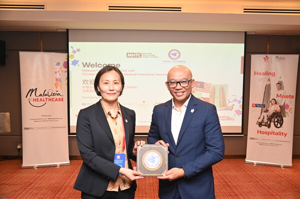 中国非公立医疗机构协会新闻发言人屈娟娟与马来西亚医疗旅游理事会营销传播副总裁Lokman Izam互赠机构纪念徽章，象征中马两国医疗合作进一步深化。