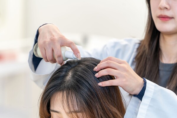 A Kolmar Korea researcher tests ‘scalp sun essence’ formulation.